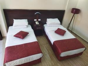 twee bedden naast elkaar in een hotelkamer bij Rendezvous hotel petra in Wadi Musa