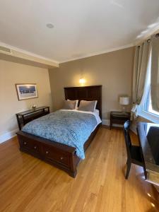 a bedroom with a bed and two tables and a window at The Century House Bed and Breakfast Ottawa in Ottawa