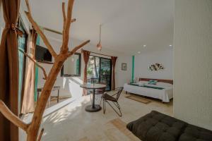 una camera con letto, tavolo e albero di Hotel Villas Tiburon Adults Only a Isola Holbox