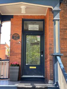a blue door on a brick building with a plant at The Century House Bed and Breakfast Ottawa in Ottawa