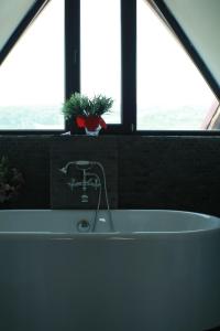 a bath tub in a bathroom with two windows at Pensiunea Clasic in Curtea de Argeş +16 photos