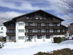 een groot gebouw met sneeuw ervoor bij Hotel Edelweiss in Innsbruck