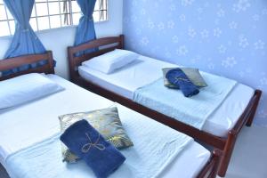 2 camas individuales en una habitación con paredes azules en BenBahrains Homestay - PB - ISLAMIC COMPLIANCE ONLY, en Masjid Tanah