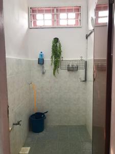 a bathroom with a plant on the wall and a bucket at BenBahrains Homestay - PB - ISLAMIC COMPLIANCE ONLY in Masjid Tanah