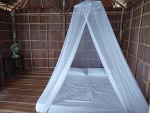 a bed with a canopy in a room at Sunset homestay in Besir
