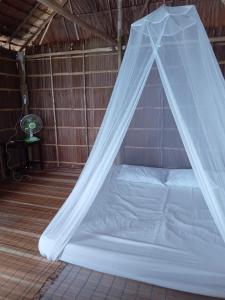 uma cama num quarto com uma rede mosquiteira em Sunset homestay em Besir