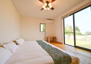 a bedroom with a large bed with a ceiling fan at Ishigaki Island Villa 7716-Vacation STAY 72439 in Ishigaki Island