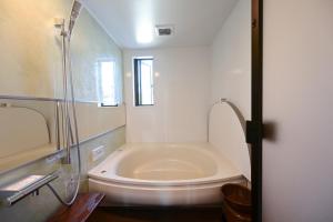 a white bathroom with a tub and a toilet at Ishigaki Island Villa 7716-Vacation STAY 72439 in Ishigaki Island
