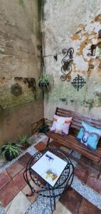 eine Bank mit Kissen und einen Tisch auf der Terrasse in der Unterkunft Artistique in Sillé-le-Guillaume