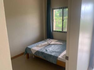 un piccolo letto in una camera con finestra di Lee's Apartment a Dumaguete
