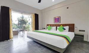 Un dormitorio con una cama grande y una ventana grande. en Treebo Grand Vistara Airport Suites, en Kochi
