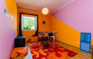 Habitación con paredes coloridas, mesa y alfombra. en Nice Home In Broce With House A Panoramic View, en Broce