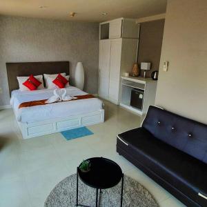 a bedroom with a large bed and a couch at Lenny's Koh Samui in Chaweng
