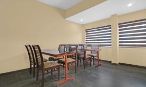 a dining room with tables and chairs and windows at Treebo Trend Grand Vistara Airport Suites in Cochin