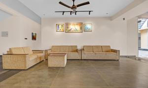 a living room with two couches and a ceiling fan at Treebo Trend Grand Vistara Airport Suites in Cochin