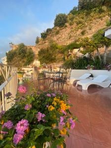 um pátio com mesas, cadeiras e flores em MAR-ISA Amalfi Coast em Vietri