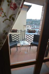 Habitación con vistas a un balcón con 2 sillas y una mesa. en Albergo Casa Al Sole en Greve in Chianti