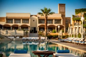 a swimming pool with lounge chairs and a hotel at Bella Beach Hotel in Hersonissos