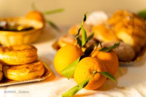 Ein paar Orangen mit grünen Blättern auf dem Tisch. in der Unterkunft MURAHERA GUEST HOUSE in Muravera