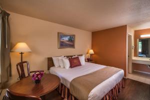ブランソンにあるウエストゲート ブランソン ウッズ リゾートの大きなベッドとテーブルが備わるホテルルームです。