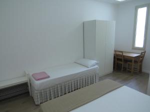 オートラントにあるラ カサ デル ジェルソ ビアンコのベッドとテーブル付きの小さな部屋