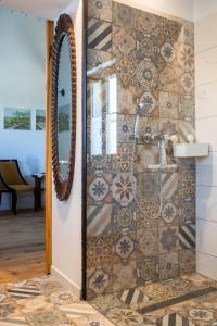 a bathroom with a shower with a tile wall at Istrian green house in Portorož