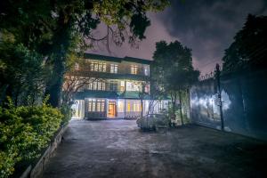 Una casa grande se ilumina por la noche en Apsara Guest House en Shillong