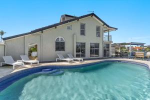 a swimming pool in front of a house at Tecoma 3 - Most Popular Waterfront in Yamba +25 photos