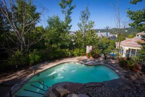 a small pool in a yard with a fence at Lodge de la Montagne in Mont-Tremblant