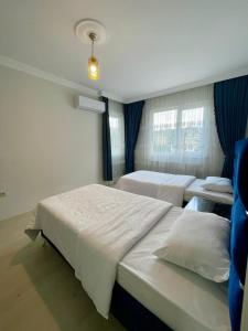 een kamer met 2 bedden en 2 ramen bij kayan apart in Trabzon