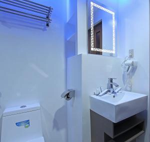 W łazience znajduje się biała umywalka i lustro. w obiekcie Bergamo Hotel w mieście Lingayen
