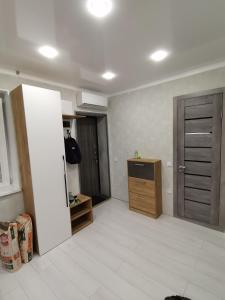 uma sala de estar vazia com uma cozinha e uma porta em Чистая уютная квартира! Рядом сквер,море em Aktau