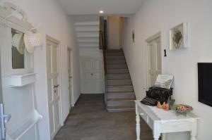a hallway with a staircase with a television and a table at White suite - Jacuzzi, Swimming pool & Lake view in Lezzeno