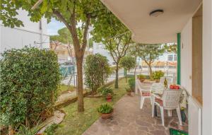 een patio met een tafel, stoelen en bomen bij Casa Del Gelsomino in Misano Adriatico