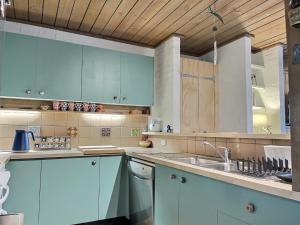 a kitchen with blue cabinets and a sink at Snow Gums Apartment 4, alpine-getaways in Dinner Plain