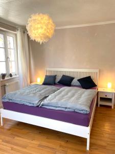 a bedroom with a large bed with a chandelier at Uriges Ferienhaus in der Altstadt von Saarburg mit Sauna, Kinderspielecke, 1000Mbit Wlan, 1 Minute vom Wasserfall entfernt in Saarburg