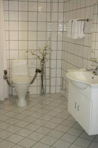 a white bathroom with a toilet and a sink at Sunde Fjord Hotel, free and easy parking in Solavagen