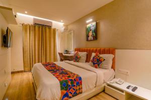 een slaapkamer met een bed en een bureau. bij FabHotel Geetraj in Lucknow
