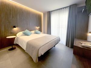 Postel nebo postele na pokoji v ubytování Hotel Quatre Llunes