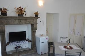 a room with a fireplace with a table and a refrigerator at Lescen White Residence - swimming pool in Lezzeno