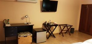 a room with a desk and a television on the wall at GuestHouse 1109 in Maputo