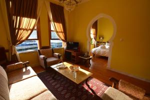 - un salon avec un canapé, une table et un lit dans l'établissement Amina Hanem Boutique Apartments, à Kavala