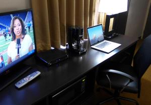 a desk with a television and two laptops on it at Waterfront Hotel and Marina in Johnsburg