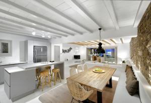 a kitchen and living room with a table and chairs at Beachfront Villa Kalafatis by Aesthia Estate in Kalafatis