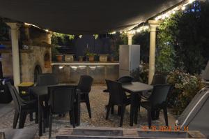 een groep tafels en stoelen op een patio 's nachts bij Villa Dacia home in Guiglia