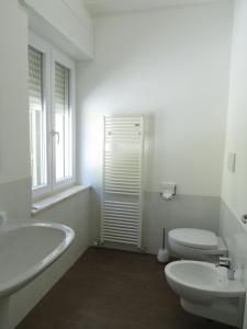 a white bathroom with a sink and a toilet at La Casa Del Gelso Bianco in Otranto