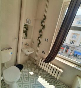 baño con aseo y lavabo y ventana en Hotello, en Sofía