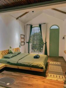 a bedroom with a large bed and a window at Green Town Mộc Châu in Mộc Châu