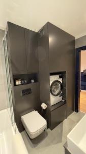 a bathroom with a toilet and a washing machine at MADOST APART MOKOTÓW 54 m2 Airport Chopin & Buisness in Warsaw