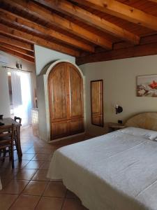 een slaapkamer met een groot bed en een houten kast bij Appartamenti La Risacca in Lampedusa